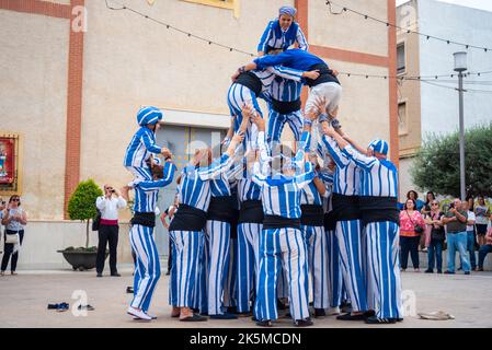 Plaza de la Iglesia, Rojales, Valencia, Spagna. 9th Ott 2022. Il 9th ottobre di ogni anno, la popolazione di Valencia celebra la giornata nazionale della propria regione autonoma. Si tratta di una commemorazione storica della data del 1238 in cui re Giacomo i entrò ufficialmente nella città di Valencia, liberandola dal dominio moresco. La data è anche la celebrazione di 40 anni di Statuto di autonomia. Gli eventi locali si svolgono nella piazza di Rojales, fuori dalla chiesa di Parroquia de San Pedro Apóstol, con gli acrobati dei Muixeranga di Alicante che eseguono piramidi umani Foto Stock