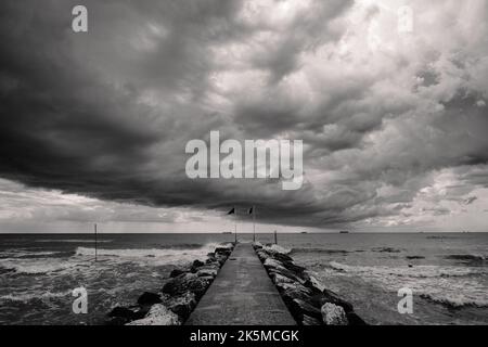 Nuvole tempeste estive sulla spiaggia di Lido di Venezia a Venezia, Italia in bianco e nero monocromatico Foto Stock