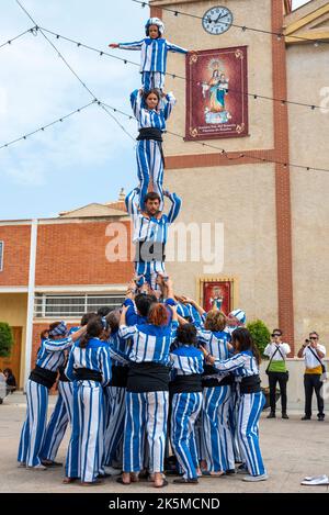 Plaza de la Iglesia, Rojales, Valencia, Spagna. 9th Ott 2022. Il 9th ottobre di ogni anno, la popolazione di Valencia celebra la giornata nazionale della propria regione autonoma. Si tratta di una commemorazione storica della data del 1238 in cui re Giacomo i entrò ufficialmente nella città di Valencia, liberandola dal dominio moresco. La data è anche la celebrazione di 40 anni di Statuto di autonomia. Gli eventi locali si svolgono nella piazza di Rojales, fuori dalla chiesa di Parroquia de San Pedro Apóstol, con gli acrobati dei Muixeranga di Alicante che eseguono piramidi umani Foto Stock