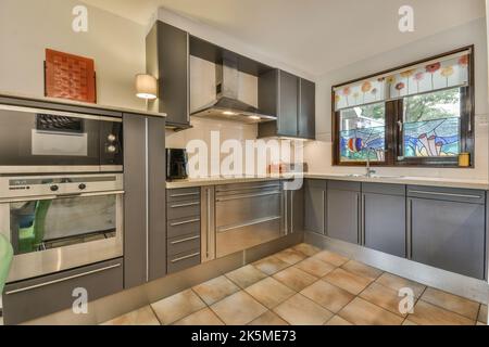 Cucina aperta nera in soggiorno bianco con divano e TV Foto Stock