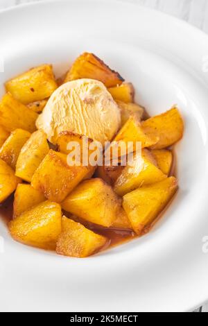 Fette di ananas caramellato arrosto con gelato Foto Stock