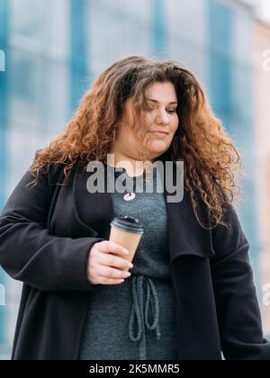 pausa caffè felice più grande donna che si gode a piedi Foto Stock