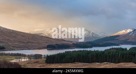 EPIC bello inverno alba panorama paesaggio immagine di luce brillante sulla catena montuosa e cime beyod Loch Tulla nelle Highlands scozzesi Foto Stock