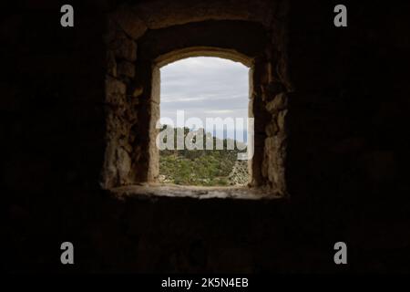 Dettagli con la vista da una finestra all'interno di una fortezza medievale sulla costa azzurra durante una nuvolosa giornata di primavera. Foto Stock