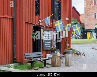 Nykoping, Svezia - 28 agosto 2019: Case di legno rosso sul fiume Nyköpingsån nella piccola città della Svezia meridionale. Nyköping, Nord Europa Foto Stock