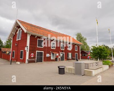 Nykoping, Svezia - 28 agosto 2019: Case di legno rosso sul fiume Nyköpingsån nella piccola città della Svezia meridionale. Nyköping, Nord Europa Foto Stock