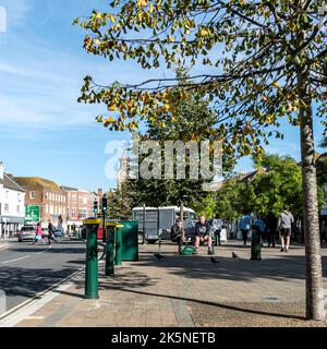 Epsom Surrey UK, 09 2022 ottobre, persone che si rilassano su Una panca o un sedile in legno High Street Foto Stock