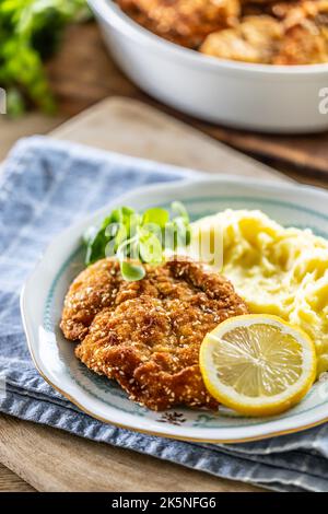 Schnitzel tradizionale con purè di patate e insalata verde servita su un piatto. Foto Stock
