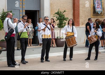 Musicisti che sostengono gli acrobati dei Muixeranga di Alicante che eseguono piramidi umani fuori dalla chiesa di Parroquia de San Pedro Apóstol a Rojales, Spagna Foto Stock