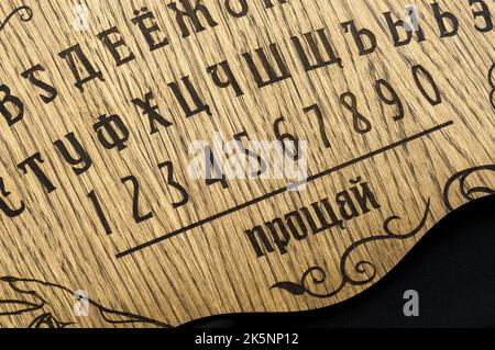 Un tavolo Ouija, giallo su sfondo nero Foto Stock