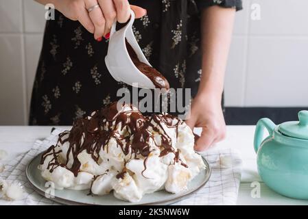 ragazza che versa il cioccolato sulla torta sancho pancho fatta in casa Foto Stock