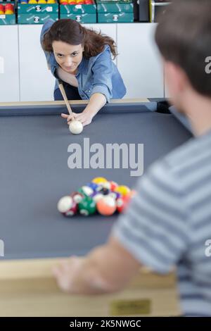 una coppia che gioca insieme al biliardo al bar Foto Stock