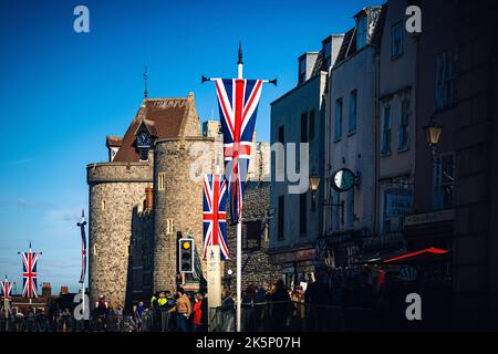 Un primo piano della bandiera del Regno Unito appese su un metallo sulla strada con gli edifici sullo sfondo Foto Stock