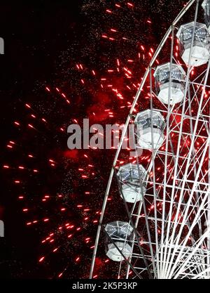 Leicester, Leicestershire, Regno Unito. 9th ottobre 2022. I fuochi d'artificio esplodono dietro la ruota della luce durante l'evento annuale di accensione delle luci Diwali sul Golden Mile. LeicesterÔs celebrazione di Diwali è una delle più grandi al di fuori dell'India. Credit Darren Staples/Alamy Live News. Foto Stock