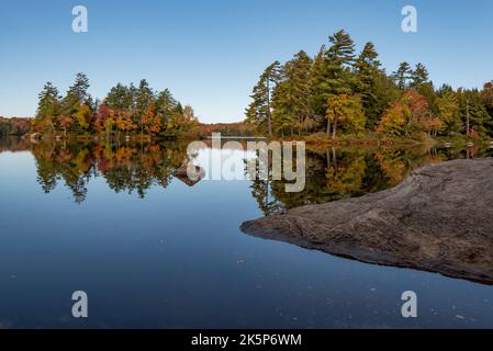 Un'isola nel lago Sacandaga in autunno vista da un campeggio in Moffit Beach state Campground a Lake Pleasant, NY USA nelle montagne Adirondack Foto Stock