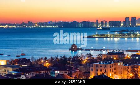 Lo scenario della citta' sul mare di Qingdao, provincia di Shandong, Cina durante il tramonto Foto Stock