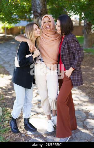 Le giovani e le ragazze sono entusiasti di abbracciare e sorridere nel parco Foto Stock