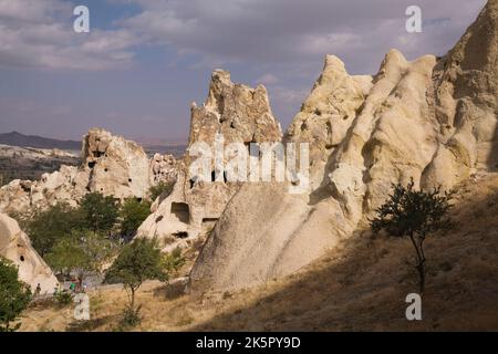 Turisti che visitano le abitazioni rupestri nella valle di Goreme, regione della Cappadocia, Turchia. Foto Stock