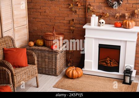 Interno del soggiorno decorato per Halloween con camino elettrico e poltrona Foto Stock