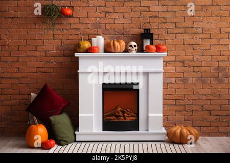 Interno del soggiorno decorato per Halloween con camino elettrico e zucche Foto Stock