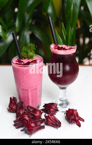 Frullato di ibisco e tè ghiacciato su una tovaglia bianca Foto Stock