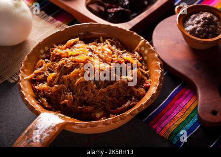 Tinga de Res. Tipico piatto messicano preparato principalmente con manzo grattugiato, cipolla e peperoncini secchi. È consuetudine servirlo su tortilla di mais tostadas Foto Stock