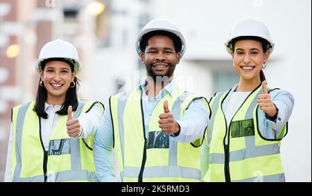 Lavoratore di costruzione, mani e pollici in su dal team in cantiere, felice con obiettivo e visione. Successo, grazie e collaborazione tra ingegneri Foto Stock