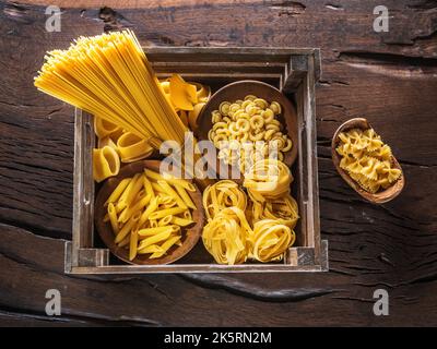 Diversi tipi di pasta nella cassa di legno. Vista dall'alto. Foto Stock