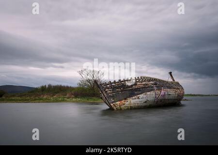 Il naufragio di Bad Eddie sulla riva di Magheraclogher Beach sotto il cielo coperto a Donegal, Irlanda Foto Stock