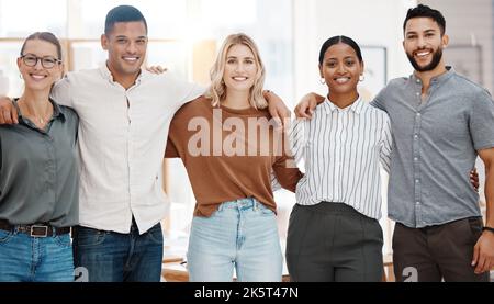 Ritratto di un gruppo di uomini d'affari diversi e sicuri in piedi con le braccia intorno l'un l'altro in un ufficio. Felice sorridente colleghi motivati e. Foto Stock