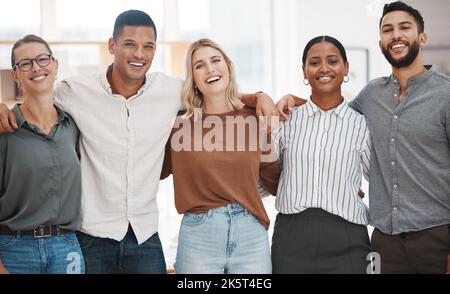 Ritratto di un gruppo di uomini d'affari diversi e sicuri in piedi con le braccia intorno l'un l'altro in un ufficio. Felice sorridente colleghi motivati e. Foto Stock