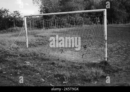 Obiettivo di calcio, foto monocromatica di un obiettivo di calcio su un campo sterrato nella zona di Cikancung, Indonesia Foto Stock