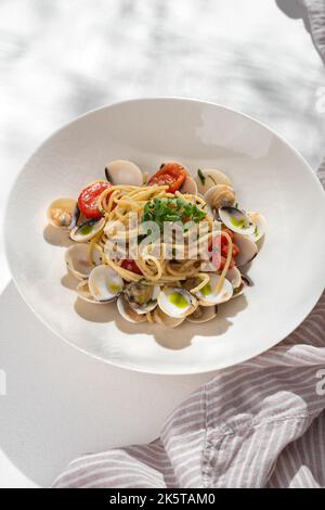 Spaghetti alle Vongole tradizionale pasta italiana di pesce con vongole fresche su sfondo bianco per il menu del ristorante. Foto Stock