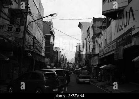 Bandung, West Java, Indonesia - 09 Ottobre, 2022 : strade cittadine, foto monocromatiche le strade di Bandung sono piene di negozi e auto parcheggiate Foto Stock