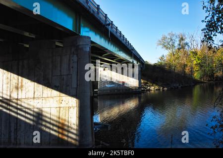 Luce del sole su cemento ponte di rinforzo sotto un ponte di strada in Onondaga Lake Park a Liverpool, New York in autunno Foto Stock