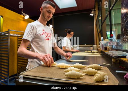 Presso la panetteria KULT, potete guardare i panettieri al lavoro attraverso il vetro. Qui si fabbricano croissant, chiamati vertici di Basilea Foto Stock