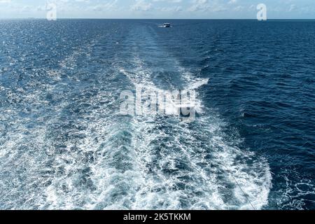 Vista dalla poppa della barca dell'effetto wake (lavaggio) sull'acqua dal motore posto sullo specchio di poppa di un lussuoso safari in barca a vela tra Mald Foto Stock