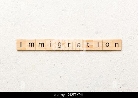 parola immigrazione scritta su blocco di legno. testo immigrazione su tavola, concetto. Foto Stock