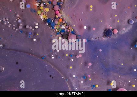 Sfere acriliche per pittura struttura astratta. Colori luminosi fluide, carta da parati scorrevole design. Miscela di liquidi viola, blu, rosa e giallo. Foto Stock