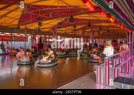 I bambini con i genitori che si divertono in auto paraurti in una fiera nella città spagnola di Fuengirola, Costa del Sol, Spagna. Foto Stock