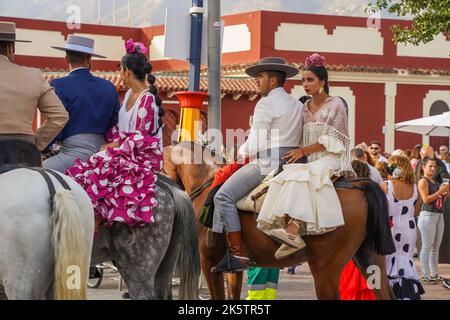 Cavalieri spagnoli in un bar, con giovane donna sul retro, durante la Fiera annuale, Feria. Fuengirola, Andalusia. Foto Stock