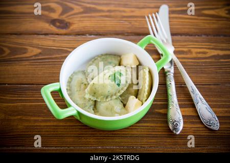 Gnocchi bolliti con ripieno interno, da impasto con erbe in un piatto di ceramica. Foto Stock