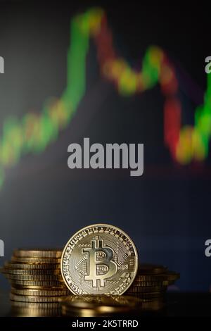 Stack o cumulo di criptocurrency Bitcoins d'oro con grafico a candela e sfondo digitale. Foto Stock