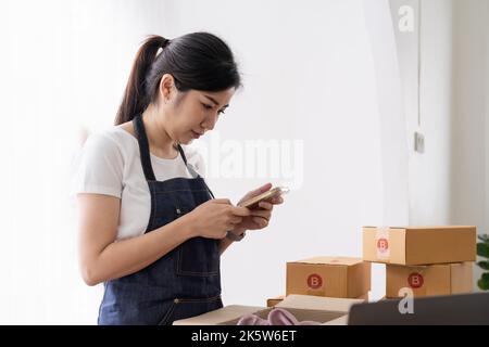 Avviare il proprietario di successo di piccole imprese, lavorando da casa con il telefono cellulare. Acquisto online ordine di acquisto e confezione. Foto Stock