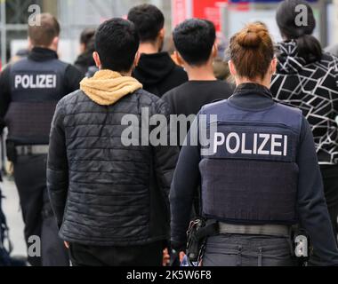 Dresda, Germania. 10th Ott 2022. Gli agenti di polizia federali conducono i rifugiati provenienti dalla Siria alla zona di immatricolazione della stazione ferroviaria principale. Credit: Robert Michael/dpa/Alamy Live News Foto Stock