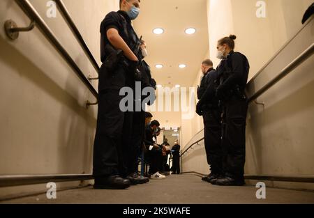 Dresda, Germania. 10th Ott 2022. I rifugiati provenienti dalla Siria attendono la registrazione nella zona di arrivo per i rifugiati alla stazione ferroviaria principale e sono accompagnati da agenti di polizia federali. Credit: Robert Michael/dpa/Alamy Live News Foto Stock