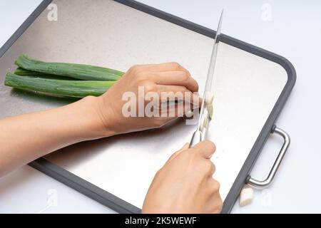 Cipolla verde tagliata su fondo bianco Foto Stock