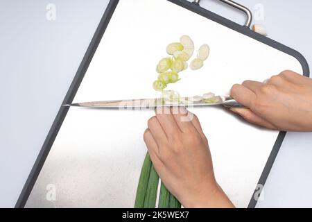 Cipolla verde tagliata su fondo bianco Foto Stock