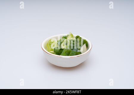 Cipolla verde tagliata su fondo bianco Foto Stock