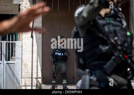 Gerusalemme, Israele. 10th Ott 2022. I soldati israeliani sono in guardia durante un'operazione di ricerca per lo sparatutto dell'attacco da tiro di sabato nel campo profughi di Shuafat. Le forze di difesa israeliane e la polizia di frontiera stanno cercando il sospettato cannoniere dietro l'attacco da tiro di sabato a un punto di controllo a Gerusalemme est, dove un soldato israeliano è stato ucciso e un altro è stato gravemente ferito. Credit: Ilia Yefimovich/dpa/Alamy Live News Foto Stock